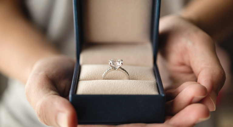 Hands Holding Diamond Ring In Jewelry Box