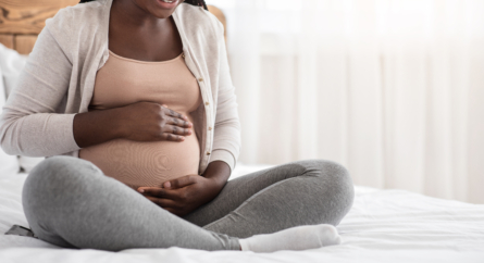 Pregnant woman sitting on bed